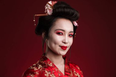 Kırmızı arka planda izole edilmiş geleneksel Japon kimonolu çekici Asyalı geyşa kadın görüntüsü