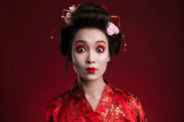 Obraz Zaskoczony Azji Geisha Kobieta Tradycyjnym Japońskim Kimono Izolowane Czerwonym — Zdjęcie stockowe