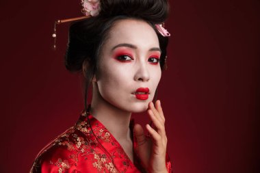 Kırmızı arka planda izole edilmiş geleneksel Japon kimonolu çekici Asyalı geyşa kadın görüntüsü