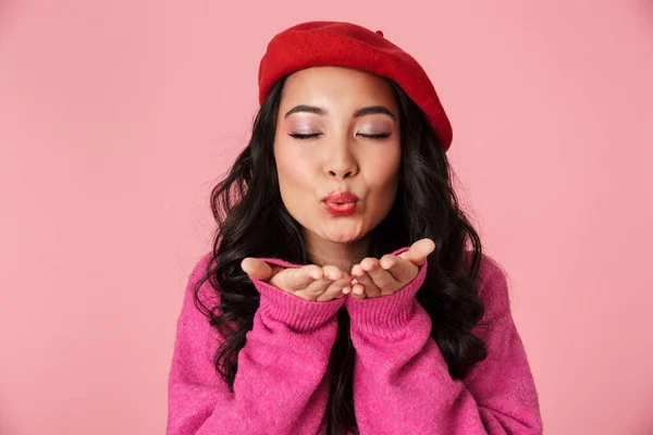 照片上年轻美丽的亚洲女孩戴着贝雷帽 在粉红的背景上飞吻着 — 图库照片