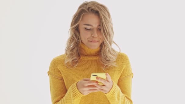 Mujer Rubia Bonita Alegre Suéter Usando Teléfono Inteligente Sobre Fondo — Vídeo de stock