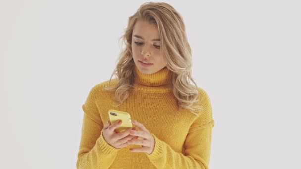 Příjemné Hezká Blondýna Žena Svetru Pomocí Smartphone Přes Šedé Pozadí — Stock video