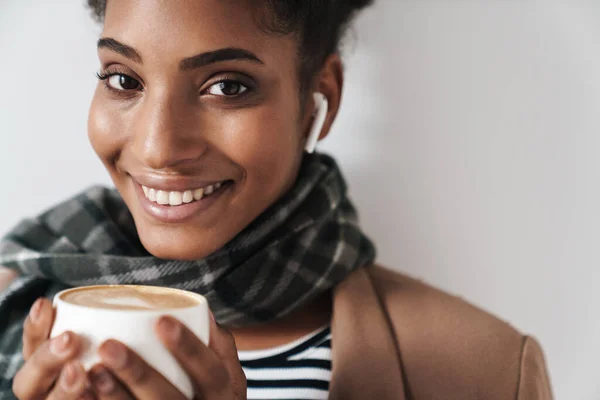 非洲裔美国微笑女人的画像 她喝咖啡 用独立于白色背景的耳脚架 — 图库照片