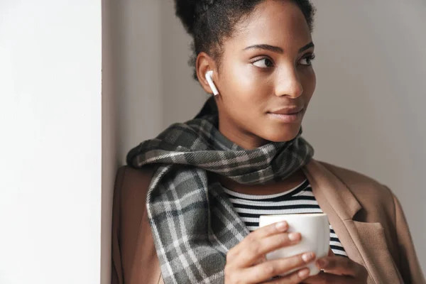Porträtt Afrikansk Amerikansk Attraktiv Kvinna Dricka Kaffe Och Använda Öronkapsel — Stockfoto