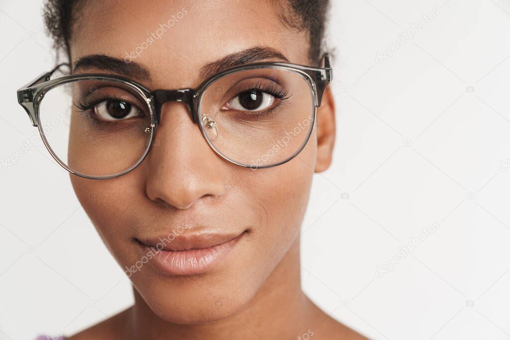 Portrait closeup of african american pleased woman in eyeglasses looking at camera isolated over white background