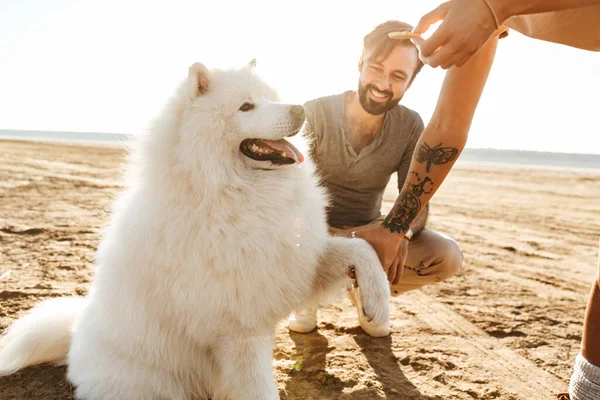 Aantrekkelijk Jong Stel Spelen Met Hun Hond Het Zonnige Strand — Stockfoto