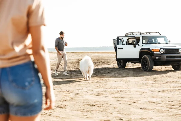 Atraente Jovem Casal Brincando Com Seu Cão Praia Ensolarada — Fotografia de Stock