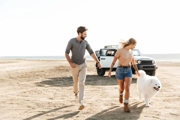 Attraktivt Ungt Par Leker Med Sin Hund Den Soliga Stranden — Stockfoto