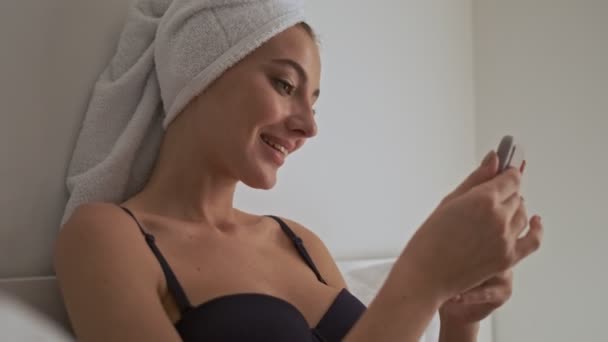 Szczęśliwa Ładna Brunetka Kobieta Bieliźnie Pomocą Smartfona Podczas Leżenia Łóżku — Wideo stockowe
