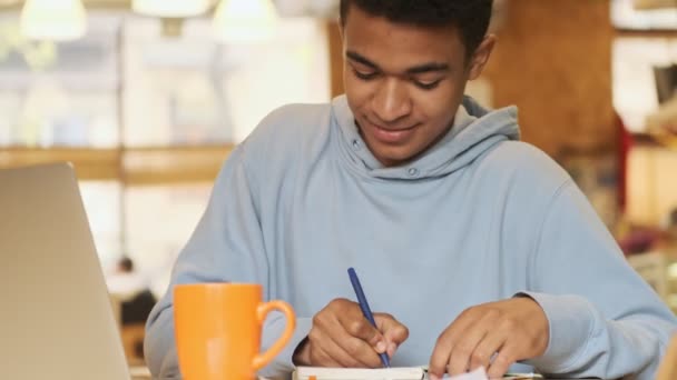 Knappe Glimlach Positief Jong Afrikaans Guy Student Studeren Doen Huiswerk — Stockvideo