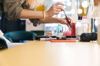 Güzellik salonunda yeni bir müşteri için aletlerini hazırlayan bir makyözün kapanışı.