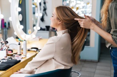 Salonda saç stilisti olan güzel bir bayan müşterinin resmi..