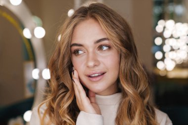 Güzeller güzeli sarışın bir kızın güzellik salonunda poz verirken fotoğrafı..