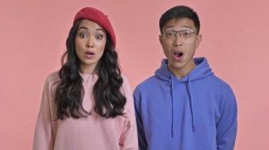 Genç, pozitif, sevimli, sevgi dolu bir çift pembe duvar arkasında izole edilmiş..