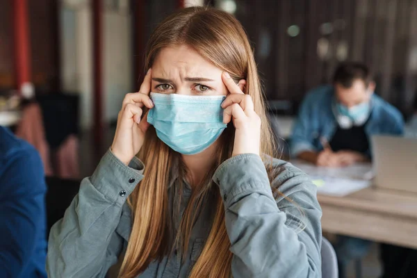 Foto Jovem Estudante Caucasiano Com Dor Cabeça Máscaras Médicas Estudando — Fotografia de Stock