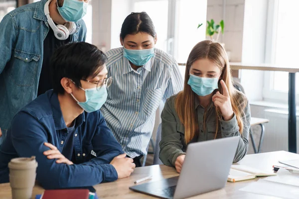 Imagem Estudantes Sérios Multinacionais Máscara Protetora Conversando Enquanto Estudavam Com — Fotografia de Stock