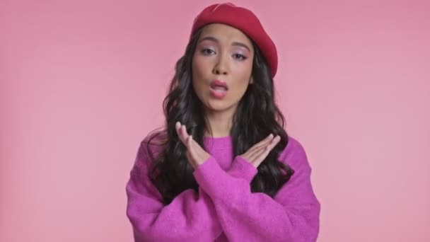真剣な若いですアジアの女性ポーズ絶縁上ピンク壁の背景言ういいえ作るストップジェスチャー — ストック動画