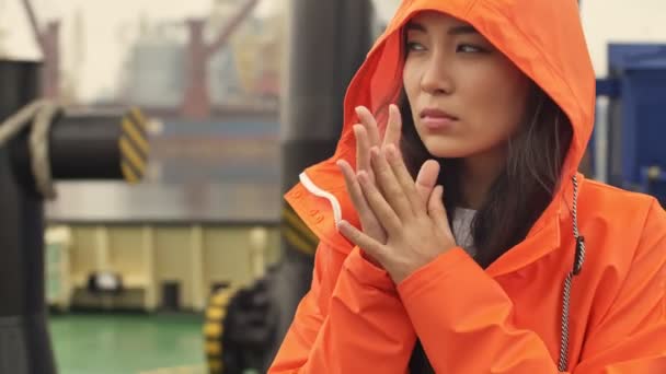 Konzentrierte Asiatische Gefrorene Frau Läuft Orangefarbenen Mantel Hafen Vorbei Und — Stockvideo
