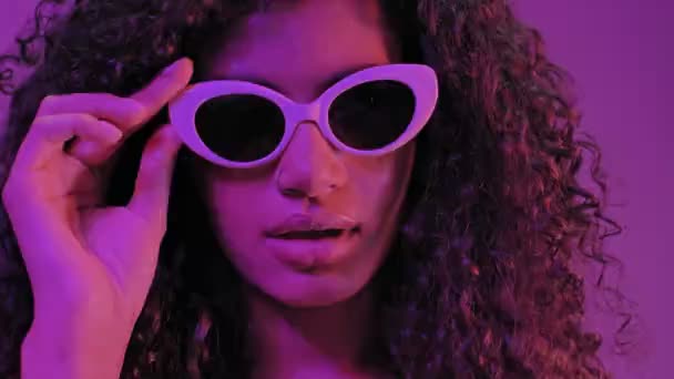 Запутавшаяся Молодая Африканская Серьезная Женщина Солнечных Очках Изолированная Неонового Фиолетового — стоковое видео