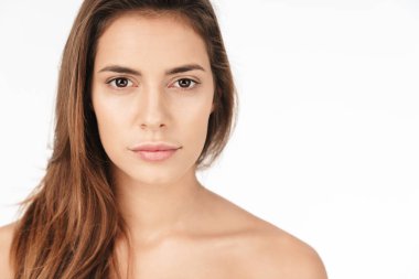 Beyaz arka planda izole edilmiş kameraya bakan güzel, genç, esmer bir kadının portresi.