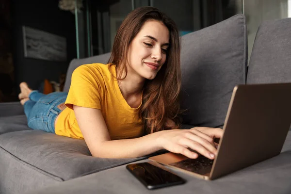 Imagem Sorrindo Jovem Mulher Bonito Usando Laptop Telefone Celular Enquanto — Fotografia de Stock