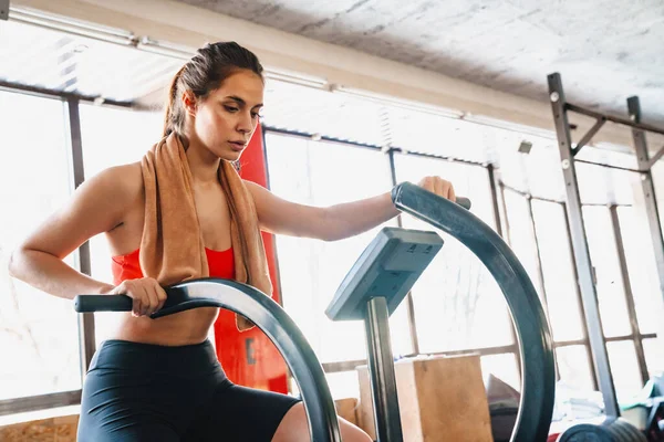 有信心的年轻迷人的女运动员在健身房的椭圆形机器上锻炼 — 图库照片