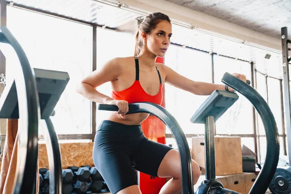 有信心的年轻迷人的女运动员在健身房的椭圆形机器上锻炼 — 图库照片