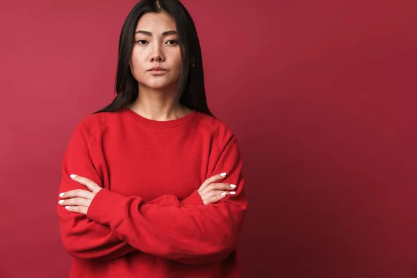 一名身穿休闲装的年轻亚洲女子的近身特写 她与红色背景隔离 双臂交叉 — 图库照片