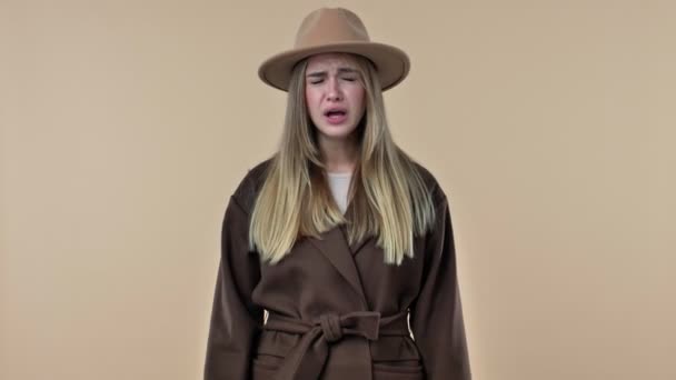 Μια Νεαρή Ελκυστική Γυναίκα Που Φοράει Καπέλο Και Παλτό Φτερνίζεται — Αρχείο Βίντεο