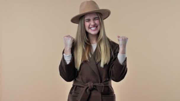 Szczęśliwa Uśmiechnięta Młoda Kobieta Kapeluszu Płaszczu Pokazuje Zwycięski Gest Odizolowany — Wideo stockowe
