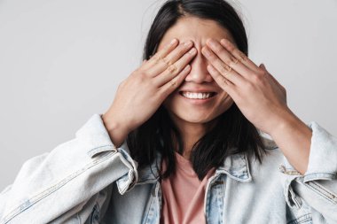 Gülümseyen ve gözlerini kapatan neşeli Asyalı adam resmi beyaz arka planda izole edilmiş.