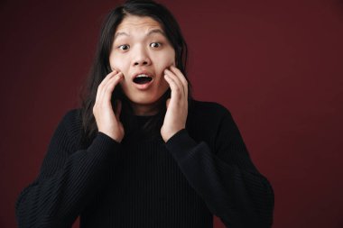 Burgonya arka planında izole edilmiş kameraya şaşırdığını ifade eden heyecanlı Asyalı bir adam görüntüsü