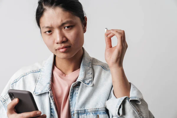 Bild Missnöjd Asiatisk Man Som Använder Mobiltelefon Och Trådlös Hörlurar — Stockfoto