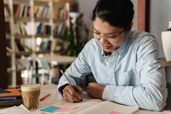 Immagine Uomo Asiatico Sorridente Con Gli Occhiali Che Studia Scrive — Foto Stock