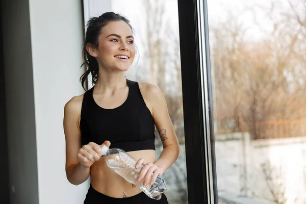 Photo Smiling Seductive Woman Sportswear Posing Bottle Water Window — Stock Photo, Image