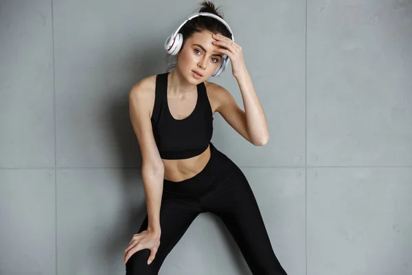 Foto Mulher Sedutora Agradável Sportswear Usando Fones Ouvido Durante Exercício — Fotografia de Stock