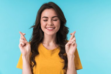 Mavi duvar arkasında izole edilmiş mutlu, pozitif bir genç kız görüntüsü umutlu olun lütfen..