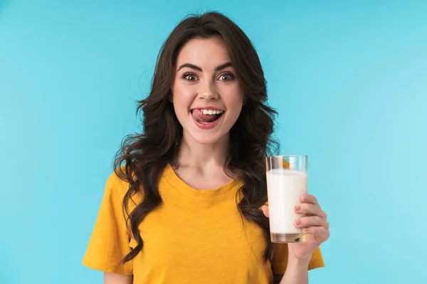 照片中 年轻而乐观的女子在蓝色墙壁的背景上 举着牛奶 显得孤立无援 — 图库照片