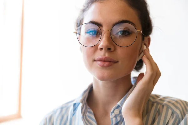 Atraktivní Usmívající Mladá Brunetka Obchodnice Nosí Bezdrátové Sluchátka Volání Kolega — Stock fotografie