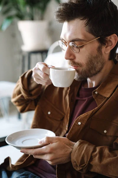 현대식 카페에서 쉬면서 안경을 마시고 잘생긴 청년의 — 스톡 사진