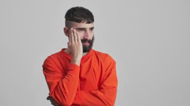 Genç, yakışıklı, sakallı esmer adamın gri duvar arkasında bir fikri var..