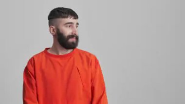 Yakışıklı, neşeli, mutlu, sakallı esmer adam. Gri duvar arka planında izole edilmiş..