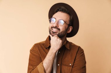 İyimser hayaller kuran bereli genç bir adam bej duvar arkasında izole edilmiş..