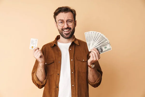 Image Confused Young Unshaved Man Isolated Beige Wall Background Holding — Stock Photo, Image