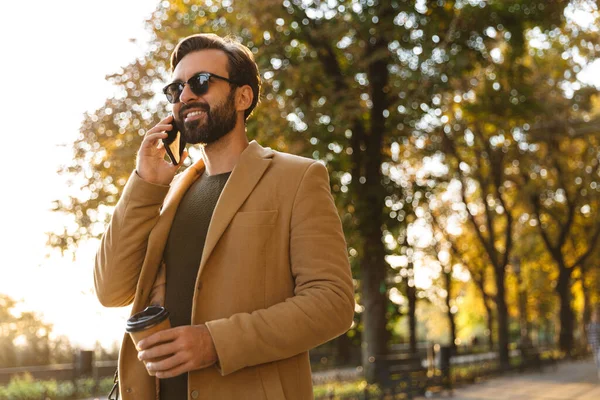 Kép Jóképű Felnőtt Férfi Dzsekiben Mosolyog Beszél Okostelefonon Séta Közben — Stock Fotó