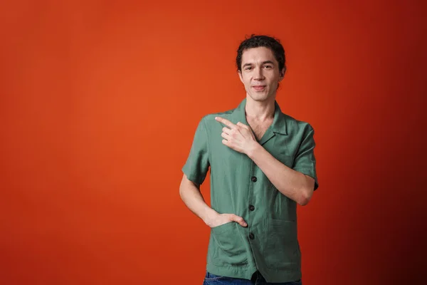 Bilde Glad Kjekk Mann Som Smiler Peker Fingeren Isolert Oransje – stockfoto