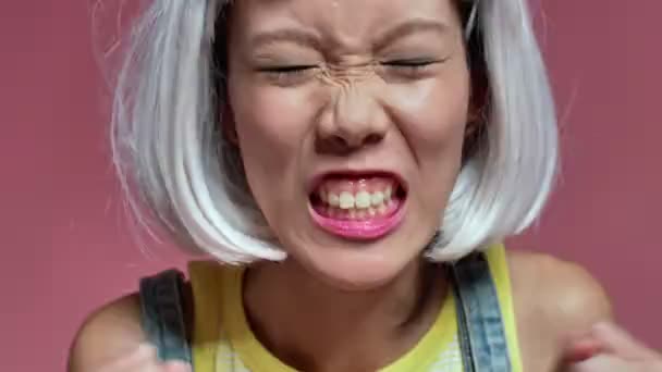 Ung Arg Aggressiv Asiatisk Flicka Isolerad Över Rosa Vägg Bakgrund — Stockvideo