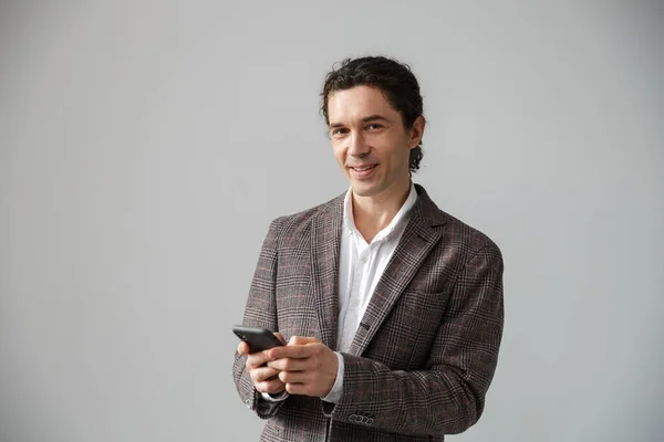 Image Pleased Handsome Man Jacket Smiling Using Cellphone Isolated White — Stock Photo, Image