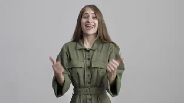Красивая Молодая Позитивная Девушка Позирует Изолированно Сером Фоне Стены Показывая — стоковое видео