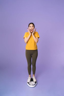 Menekşe arka planında soyutlanmış neşeli, genç ve güzel bir kadın.